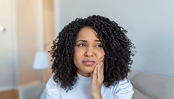 Woman experiencing toothache at home