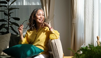 a woman holding her glasses in her hands and smiling