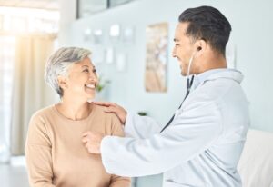 Doctor listening to senior woman’s heartbeat