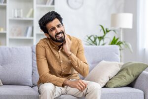 younger man holding his face in pain